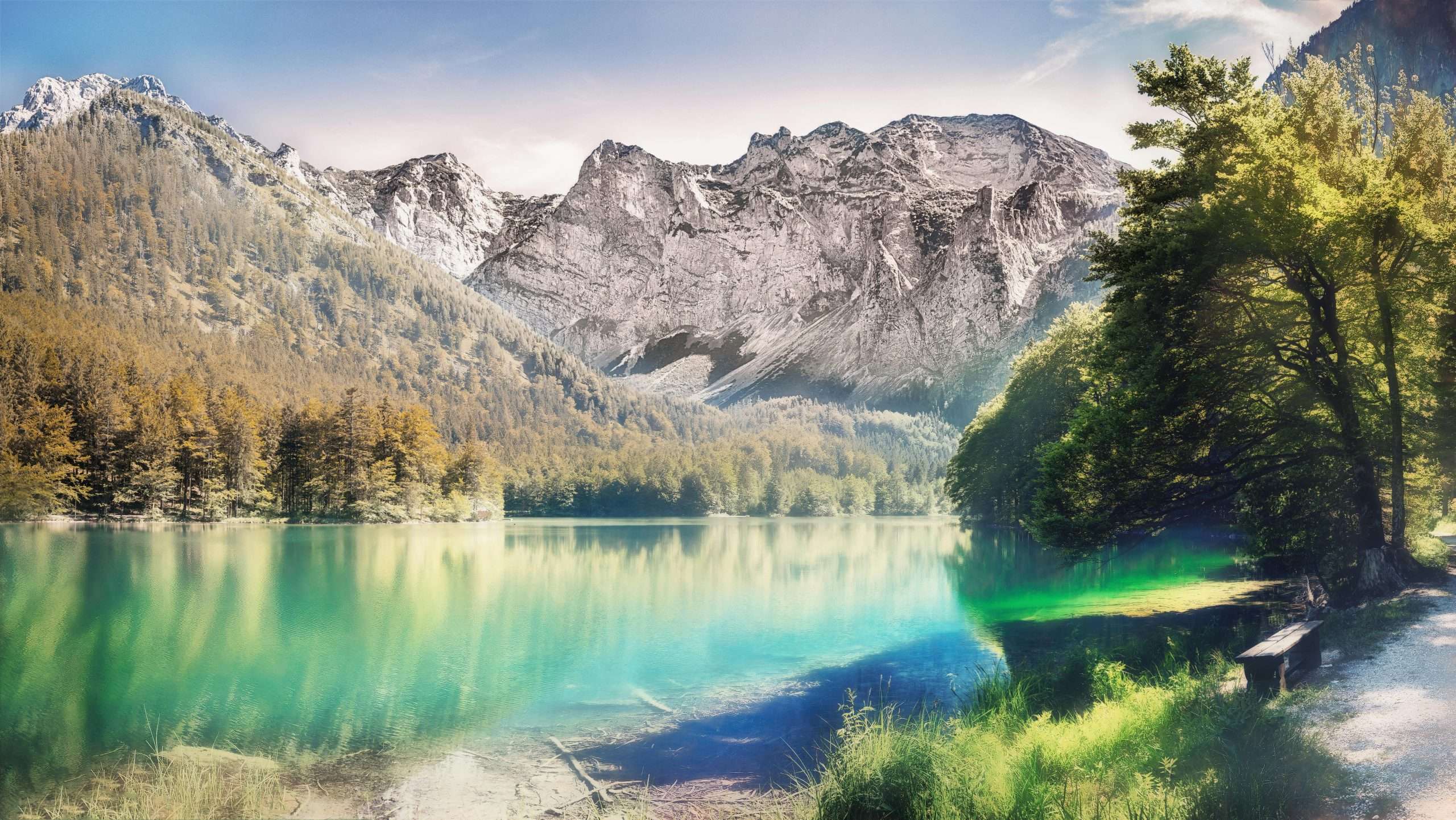 Stunning view of a serene alpine lake surrounded by majestic mountains and lush greenery in Austria.