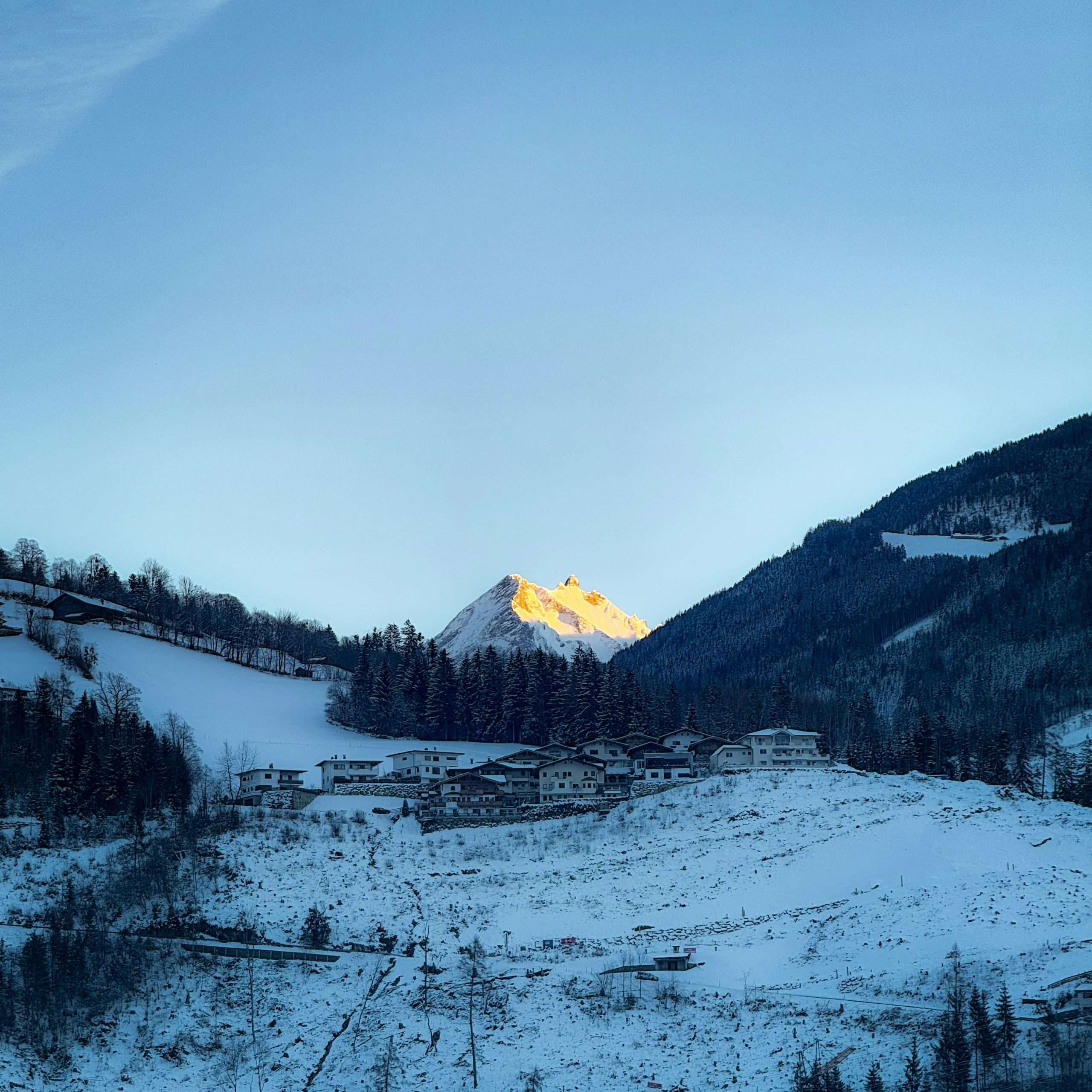 Beautiful winter mountain scene at sunset in Tyrol, Austria with snow-covered village.